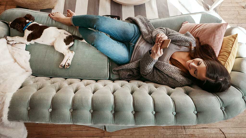 Woman and her dog lying comfortably on a couch